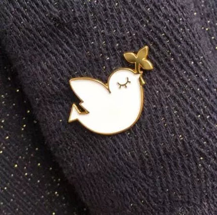 Pin's oiseau blanc et doré 
